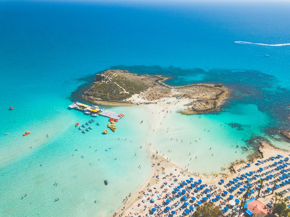 Flygvy över sandstranden och den lilla ön vid Nissi Beach i Ayia Napa